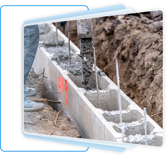 Construction worker pouring wet concrete into reinforced cinder blocks for a building foundation.