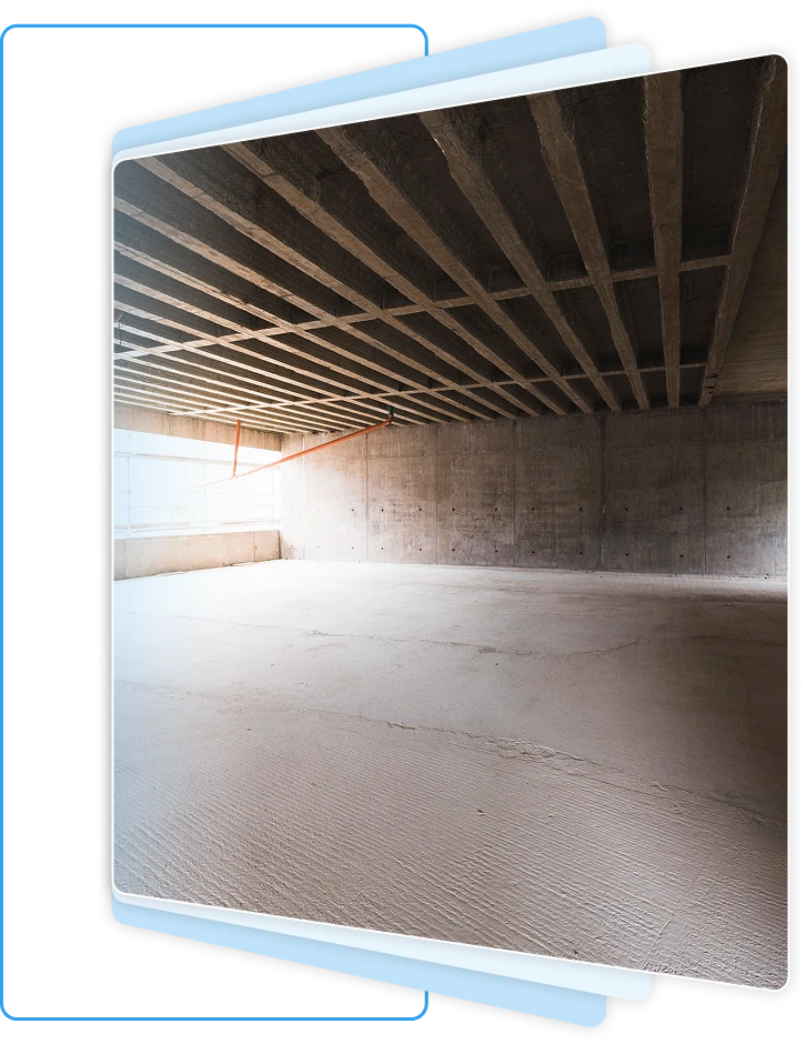 Interior view of a dry, unfinished basement showing clean concrete walls and exposed wooden ceiling joists.