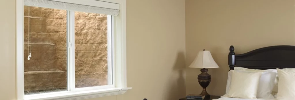 Egress window installation service showing a finished basement bedroom.