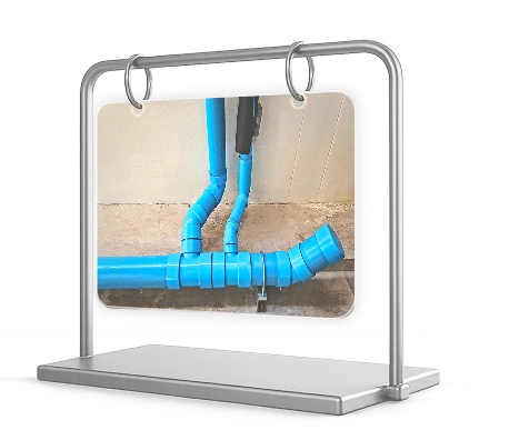 Network of blue PVC plumbing pipes installed along a concrete surface.