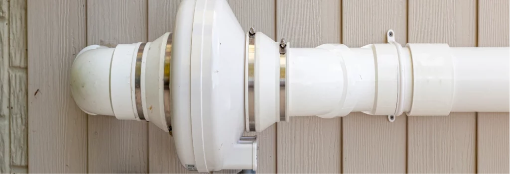 Radon mitigation service showing an exterior vent fan and PVC piping installation.