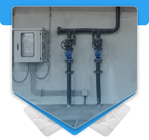 Basement wall plumbing configuration showcasing insulated water pipes and gray utility control boxes.