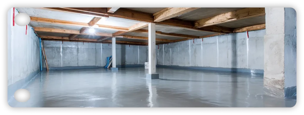 Clean unfinished basement featuring a highly reflective grey epoxy floor coating and exposed wooden joists.